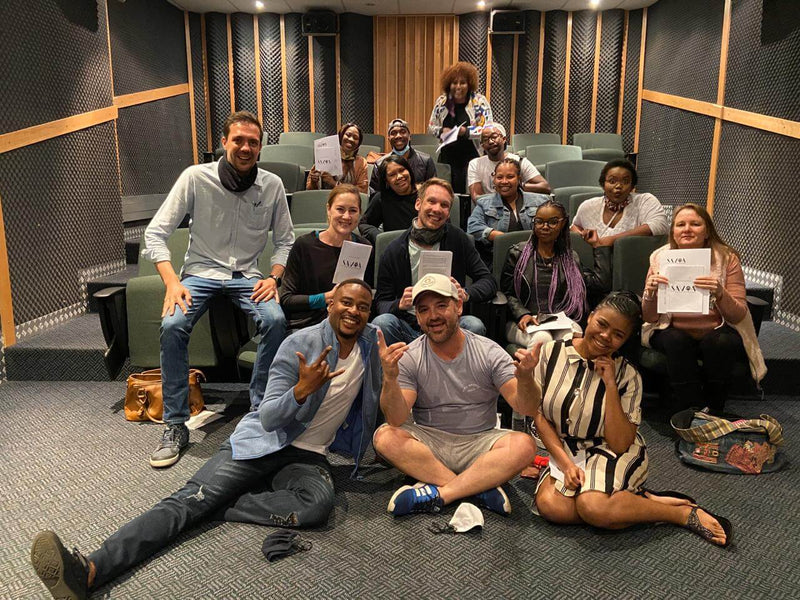 Group of enthusiastic participants at a Voice Over Workshop, engaged and ready to learn in a studio setting.